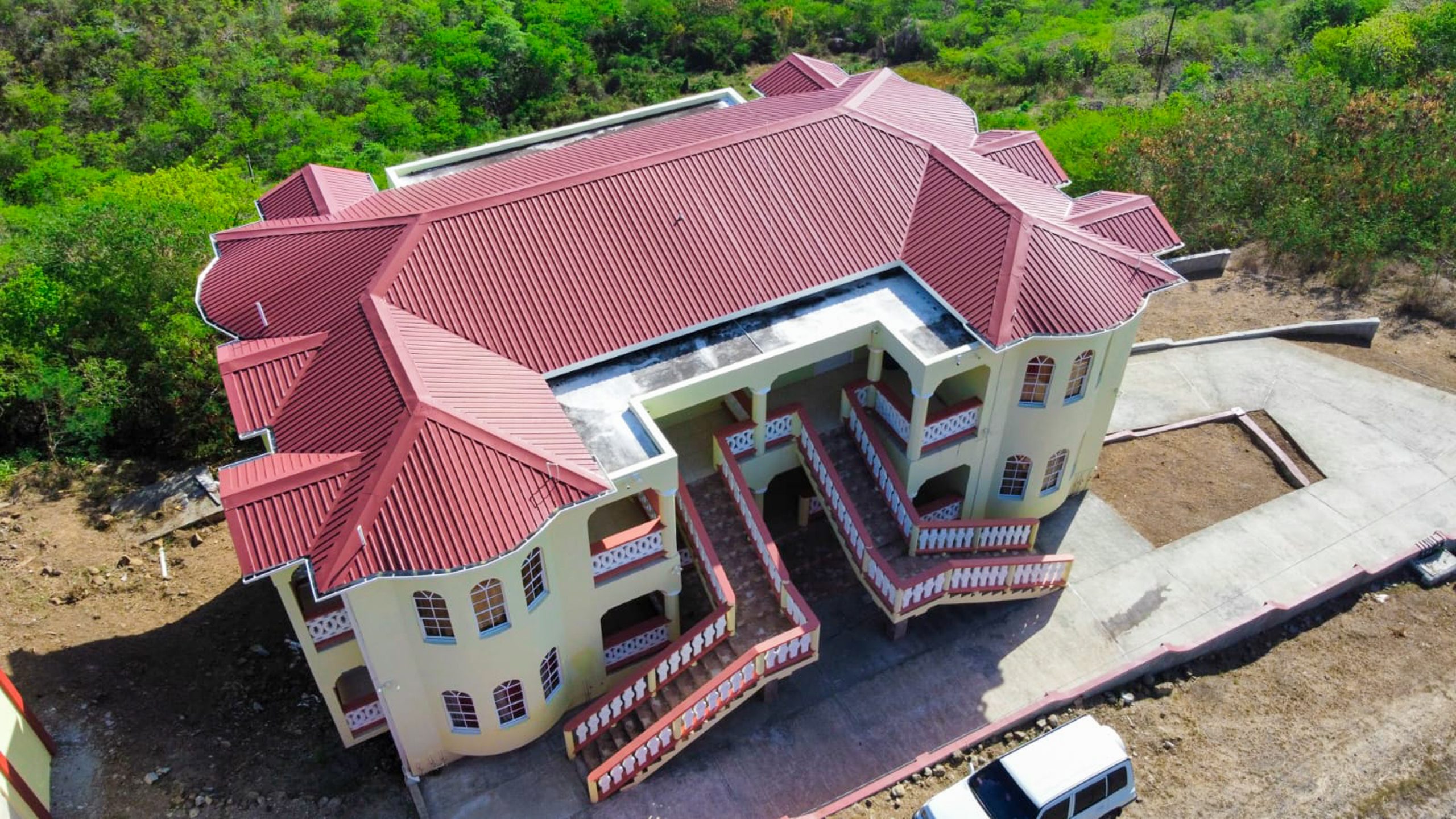 A large building with red roof and white stairs.